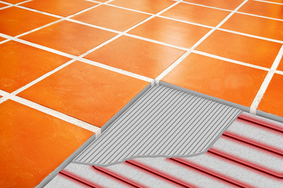 Photo and illustration of ComfortTile radiant floor heating cable shown under tile and thinset.